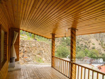 تصویر اقامتگاه چوبی با چشم انداز جنگل و کوه